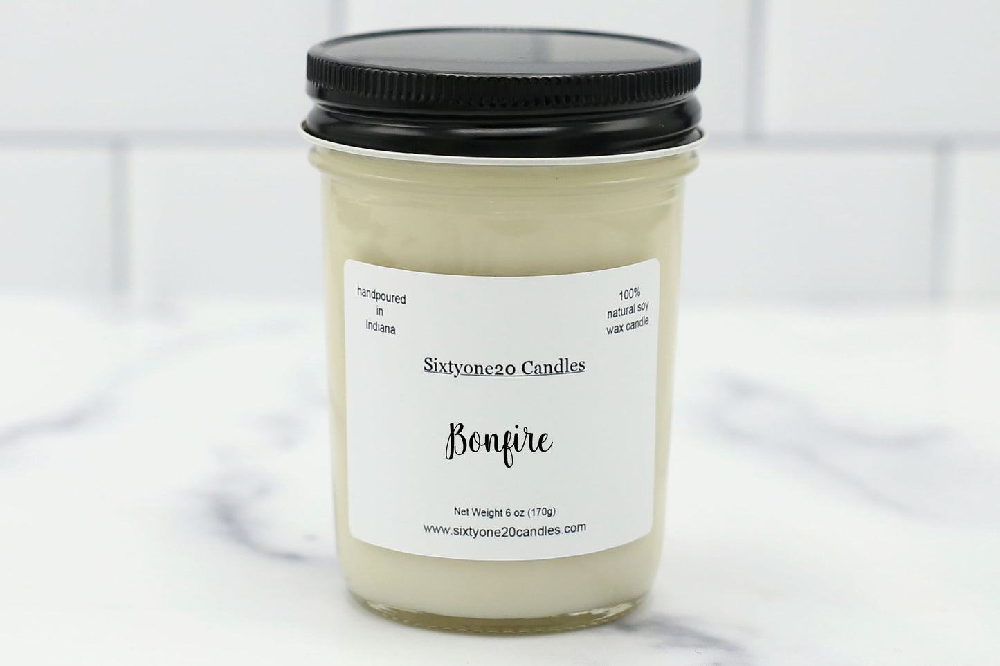 Bonfire scented 8 oz soy candle in a clear jar with black lid from Sixtyone20 Candles