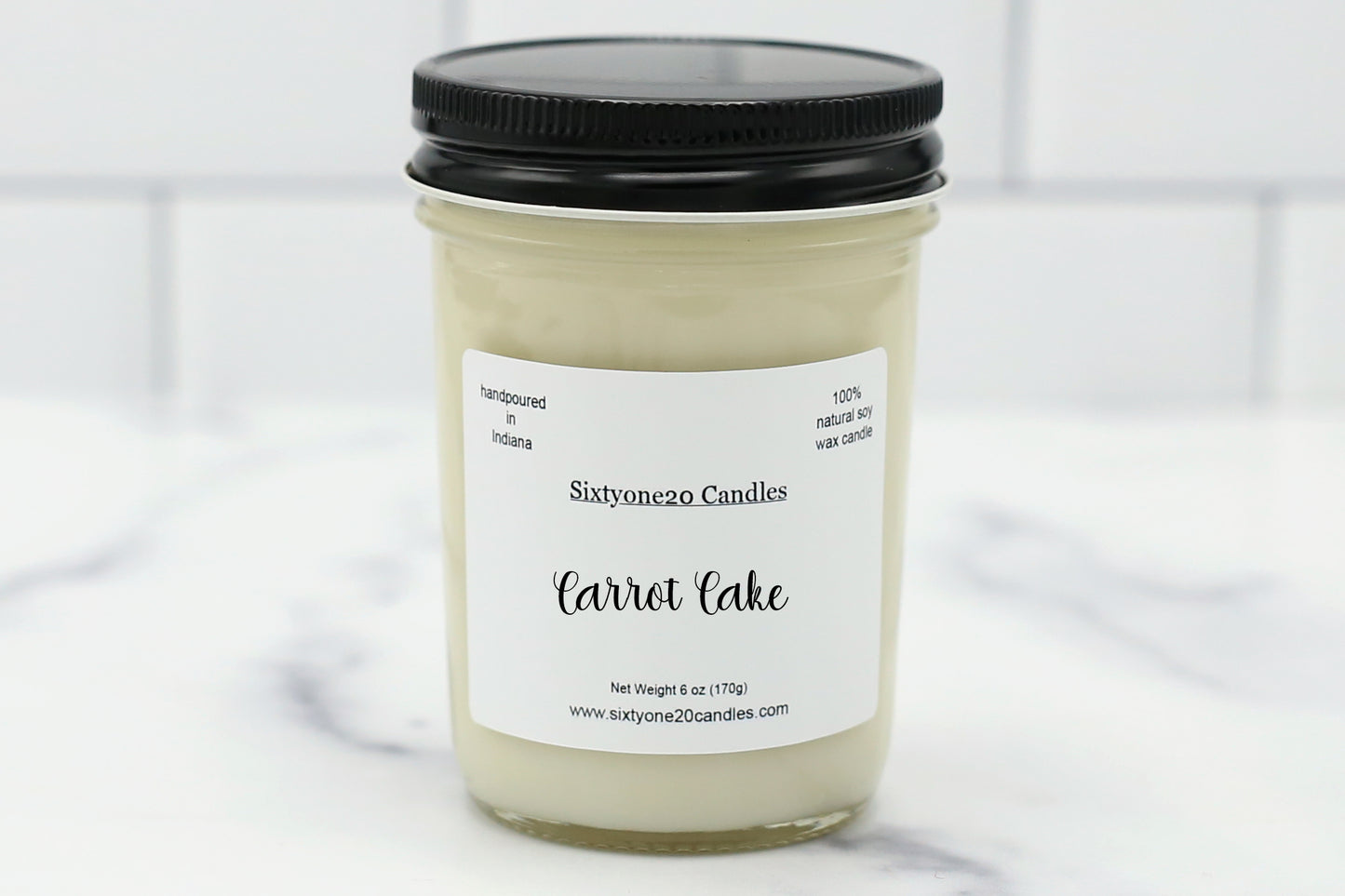 A hand-poured soy wax candle in a reusable glass jar, labeled "Carrot Cake". The candle emits a warm, spiced bakery aroma with notes of orange, carrot, cinnamon, nutmeg, vanilla bean, and maple sugar—perfect for creating a cozy and inviting space.