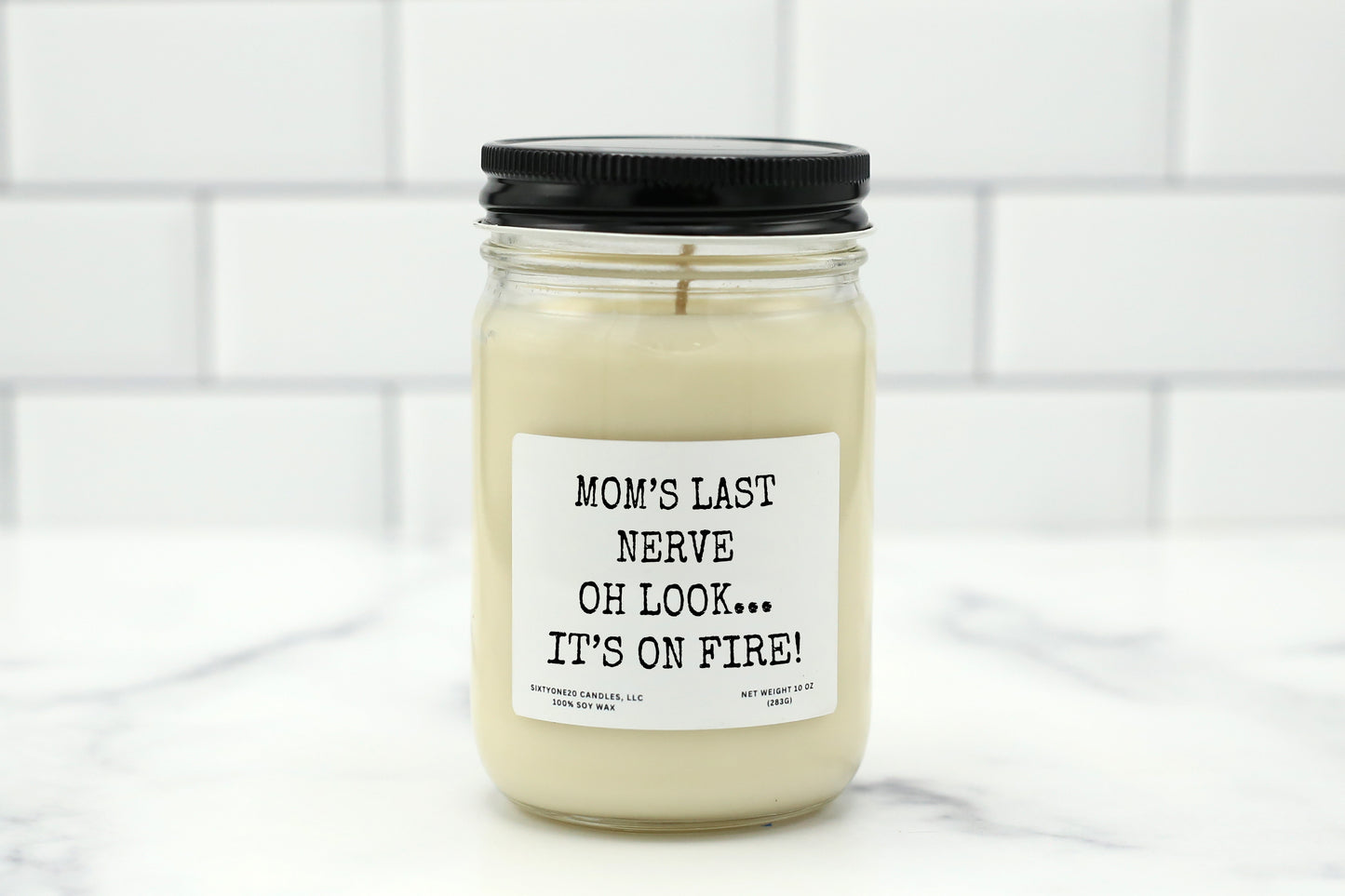 A 10 oz handmade soy wax candle with the label "Mom's Last Nerve—Oh Look... It's On Fire!"—a funny Mother’s Day gift available in 10 custom scents.