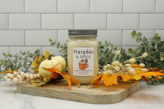 Pumpkin & Spice Candle Club subscription soy candle in a mason jar, styled with fall leaves and a white pumpkin, handmade by Sixtyone20 Candles in Bloomington, Indiana.