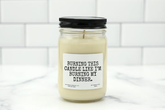 A 10 oz handmade soy wax candle with the label "Burning This Candle Like I’m Burning My Dinner"—a funny gift available in 10 custom scents, perfect for housewarmings, birthdays, or kitchen decor.