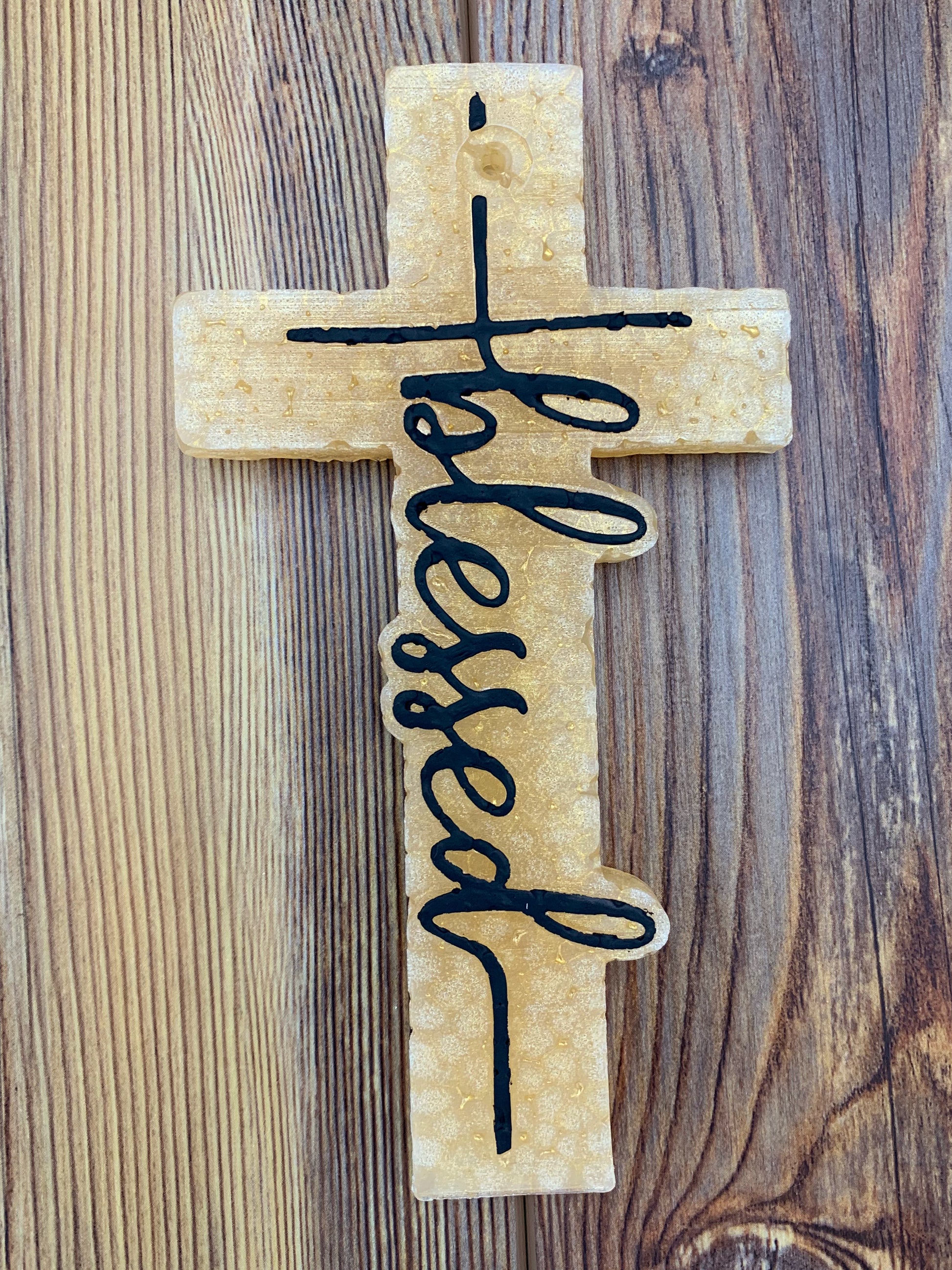 Cross-shaped freshie with the word 'Blessed' displayed prominently. This freshie features a detailed design, perfect for adding a comforting, faith-inspired touch and fragrance to your car or space.