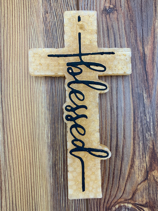 Cross-shaped freshie with the word 'Blessed' displayed prominently. This freshie features a detailed design, perfect for adding a comforting, faith-inspired touch and fragrance to your car or space.