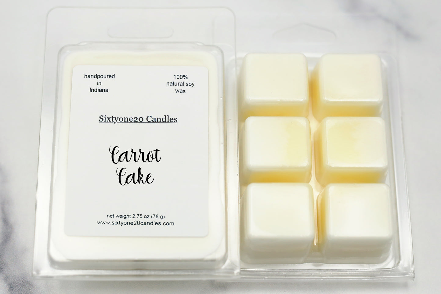 A clamshell of hand-poured soy wax melts labeled "Carrot Cake". The melts release a warm, spiced bakery aroma with notes of orange, carrot, cinnamon, nutmeg, vanilla bean, and maple sugar—perfect for a cozy home fragrance.