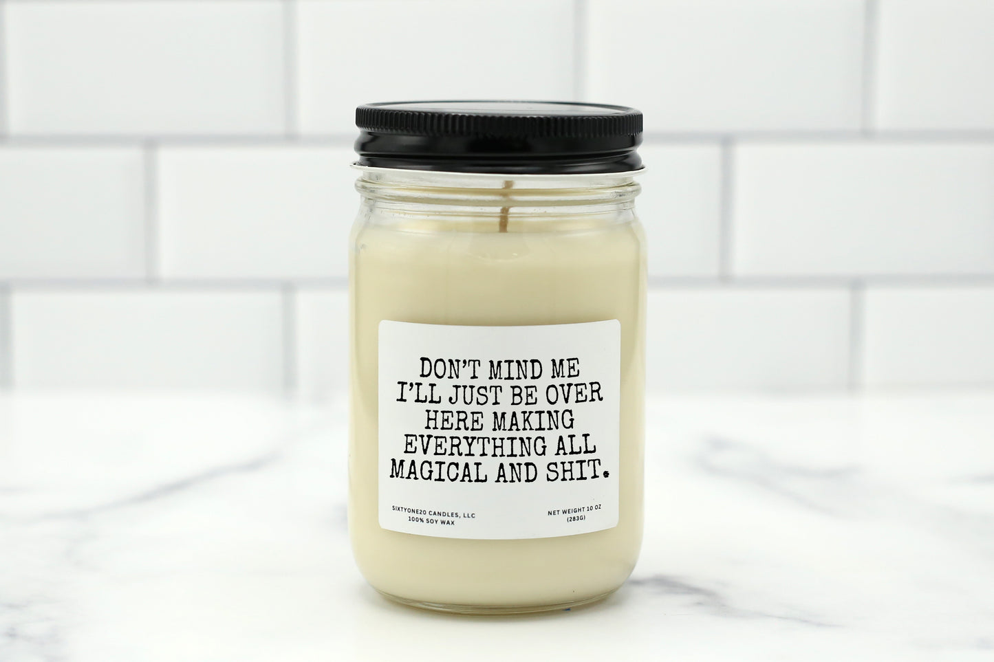 A 10 oz handmade soy wax candle with the label "Don’t Mind Me, I’ll Just Be Over Here Making Everything All Magical and Shit"—a funny gift available in 10 custom scents, perfect for birthdays or just-because gifts.