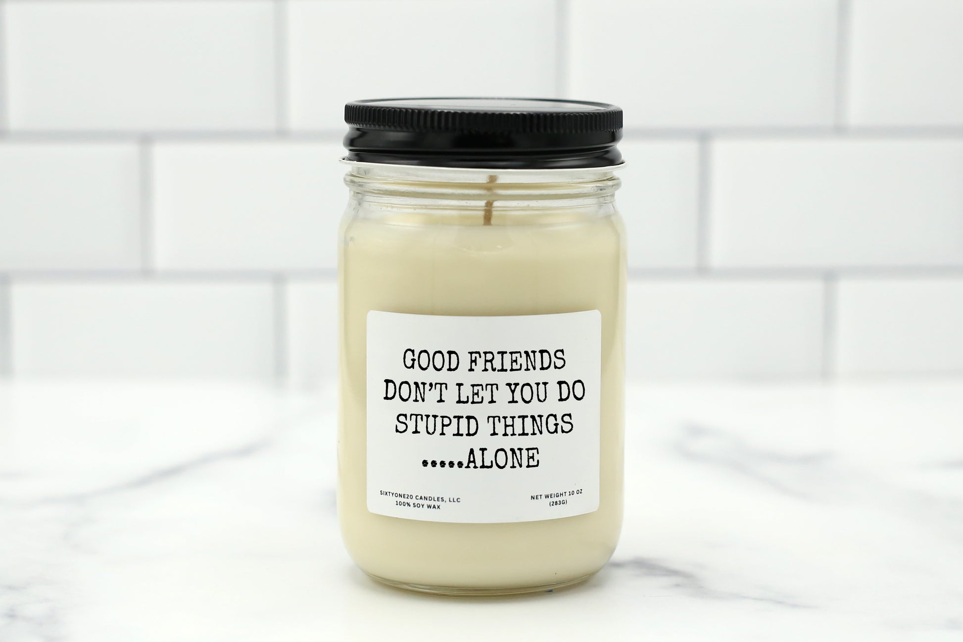 A 10 oz handmade soy wax candle with the label "Good Friends Don’t Let You Do Stupid Things... Alone"—a funny friendship gift available in 10 custom scents, perfect for birthdays, besties, or Galentine’s Day.