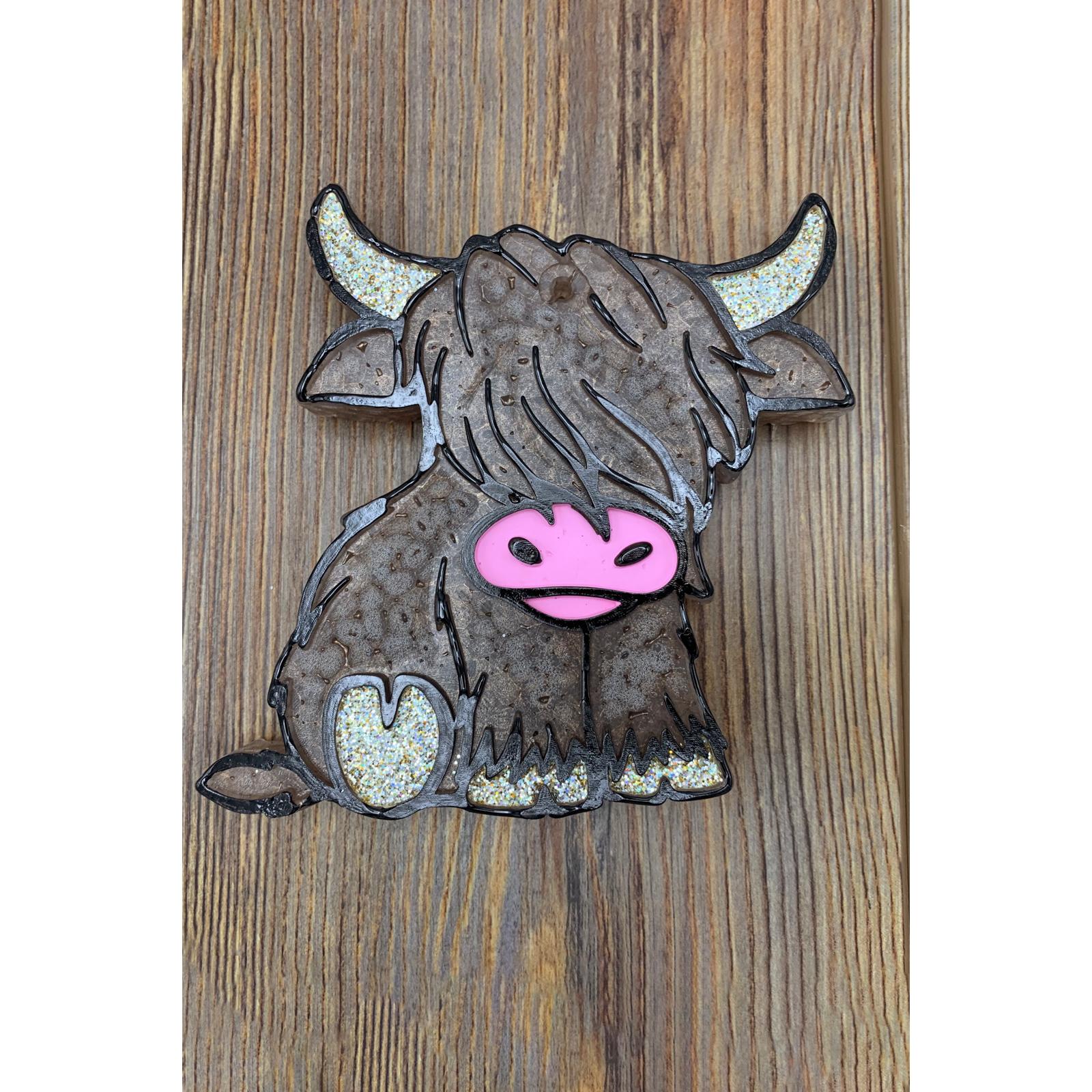 brown highland cow car freshie with shaggy hair on wood background