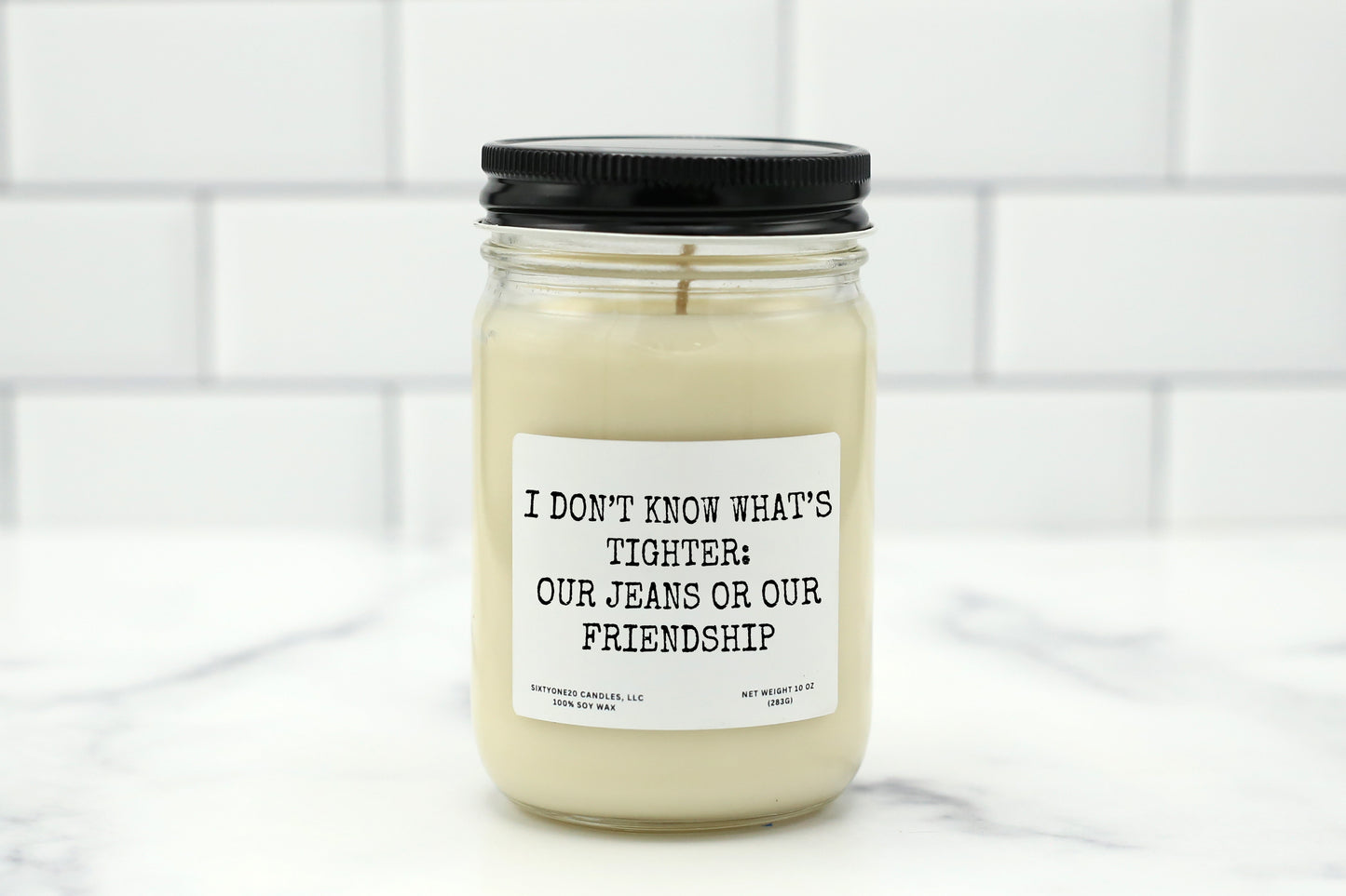 A 10 oz handmade soy wax candle with the label "I Don’t Know What’s Tighter: Our Jeans or Our Friendship"—a funny gift available in 10 custom scents, perfect for best friends, birthdays, or Galentine’s Day.