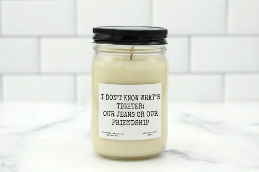 A 10 oz handmade soy wax candle with the label "I Don’t Know What’s Tighter: Our Jeans or Our Friendship"—a funny gift available in 10 custom scents, perfect for best friends, birthdays, or Galentine’s Day.