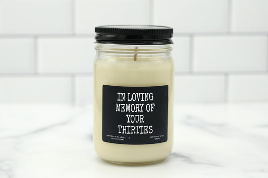 A 10 oz handmade soy wax candle with the label "In Loving Memory of Your Thirties"—a funny, milestone birthday gift available in 10 custom scents.