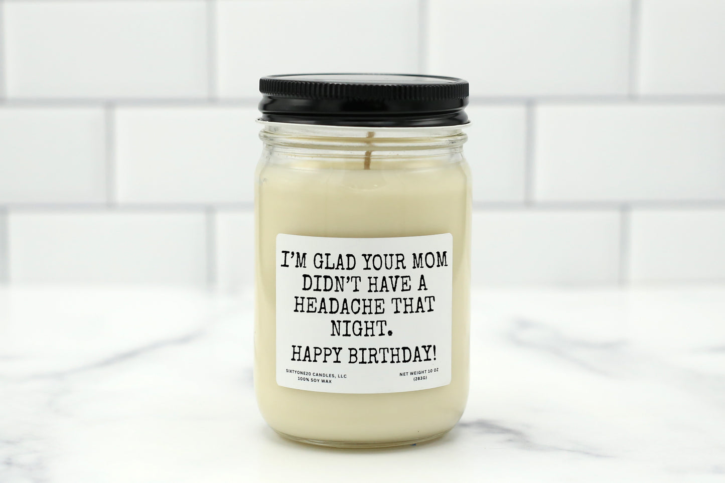 A 10 oz handmade soy wax candle with the label "I’m Glad Your Mom Didn’t Have a Headache That Night. Happy Birthday!"—a funny gift in 10 scent options.