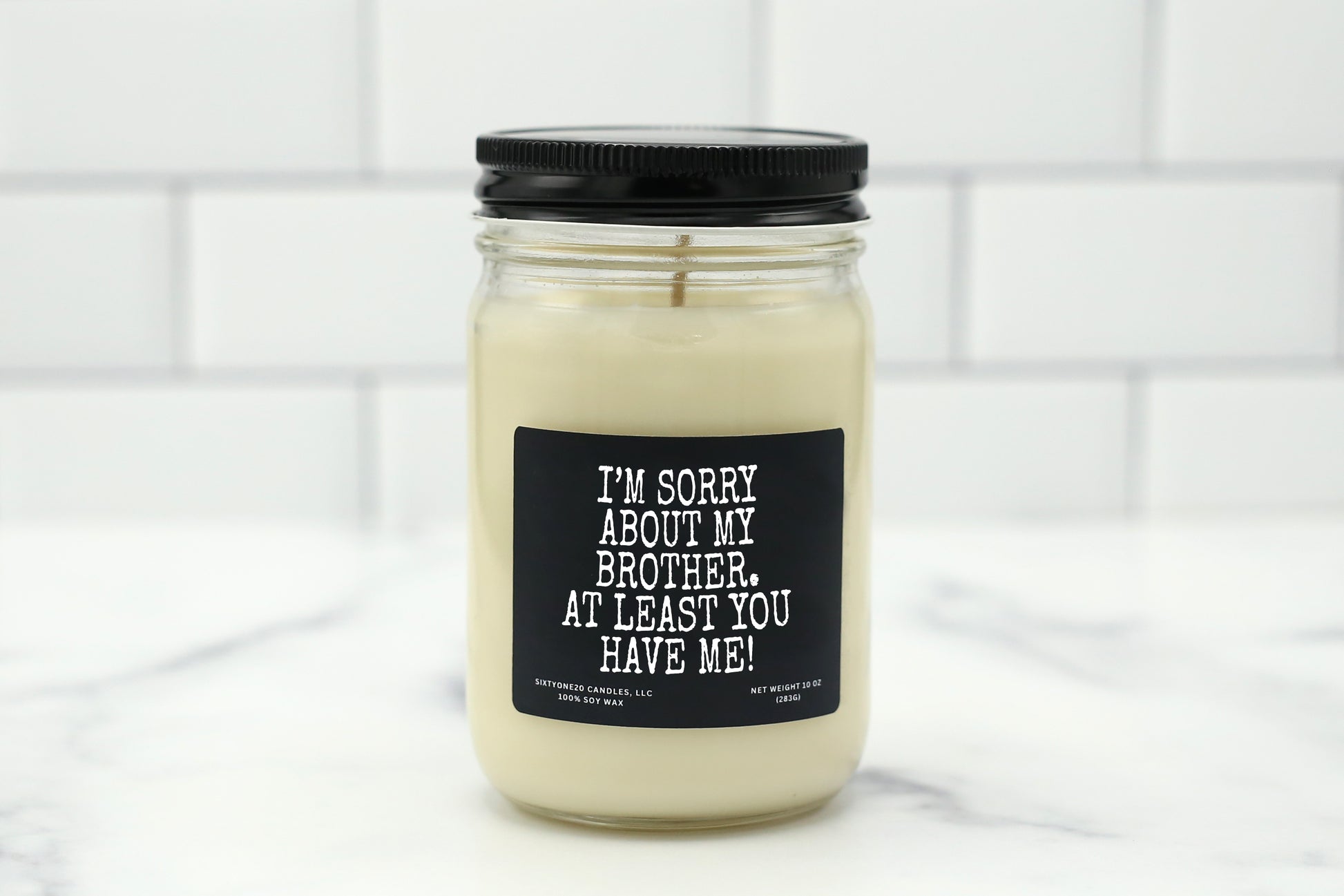 A 10 oz handmade soy wax candle with the label "I’m Sorry About My Brother. At Least You Have Me!"—a funny gift available in 10 custom scents, perfect for Mother’s Day, Father’s Day, or any occasion.