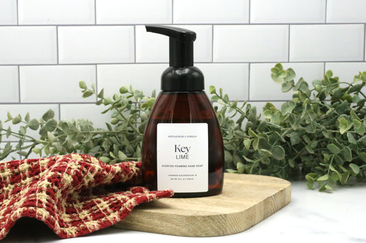 Key Lime foaming hand soap by Sixtyone20 Candles on a wooden board with red towel and eucalyptus greenery in the background