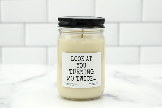 A 10 oz handmade soy wax candle with the label "Look at You Turning 20 Twice"—a funny 40th birthday gift available in 10 custom scents.