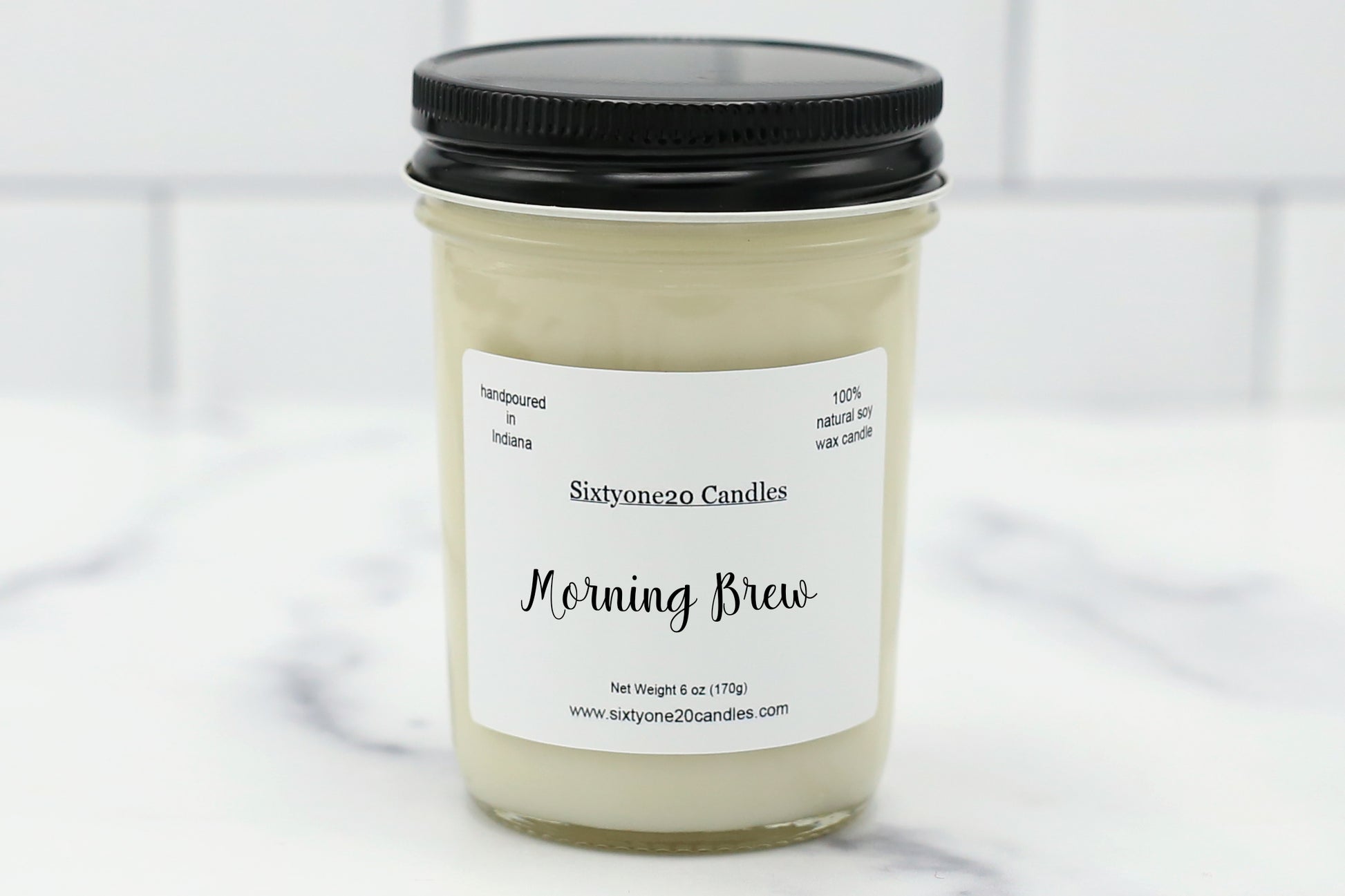 Morning Brew soy candle in a clear jar with black lid, labeled and displayed on white tile background