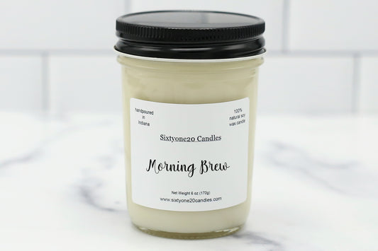 Morning Brew soy candle in a clear jar with black lid, labeled and displayed on white tile background