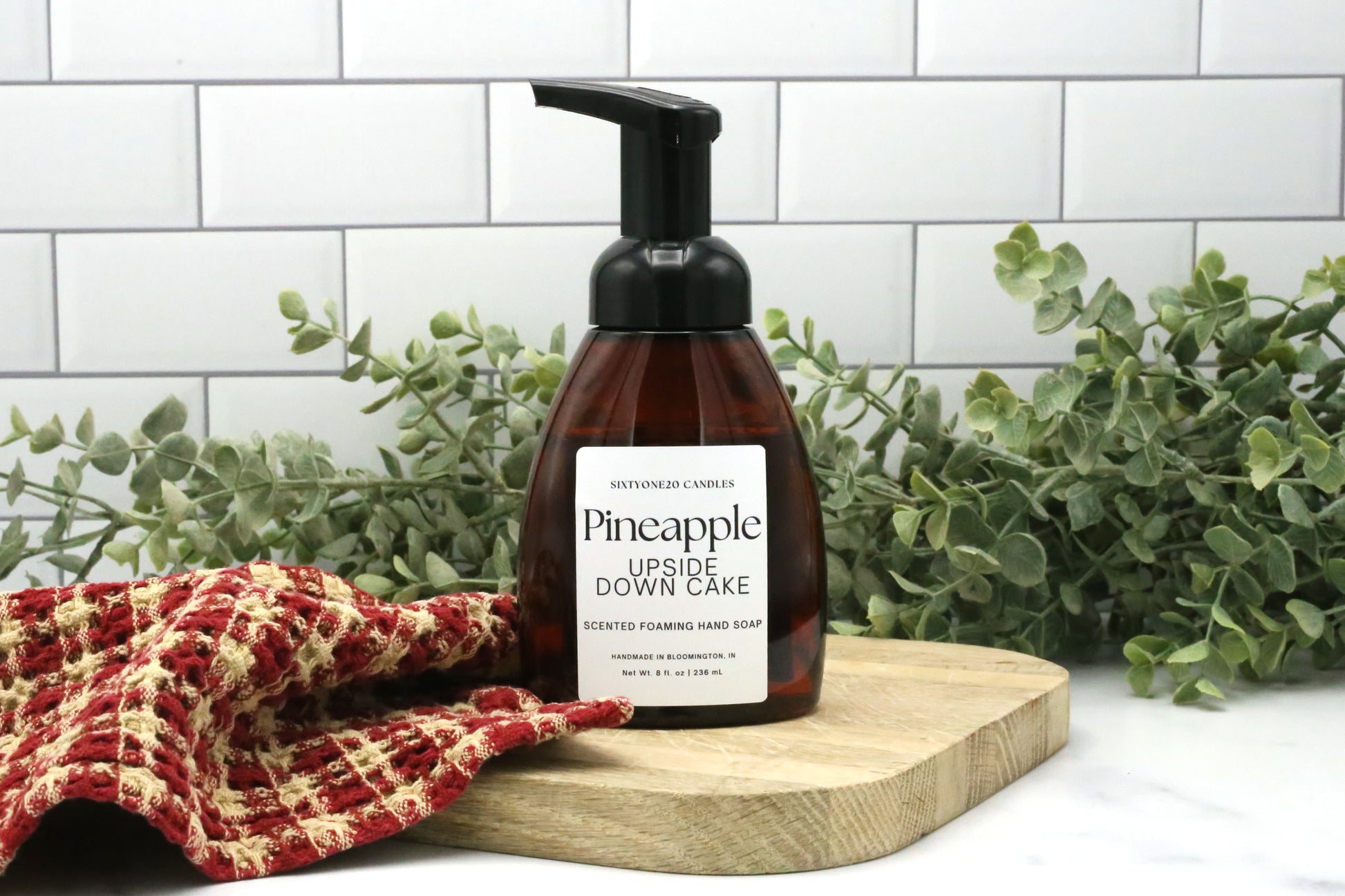 Pineapple Upside Down Cake foaming hand soap by Sixtyone20 Candles on a wooden board with red towel and eucalyptus greenery